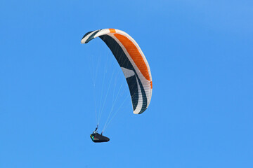 Paraglider flying in a blue sky	
