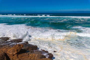 Powerful waves crash against rugged coastal rocks