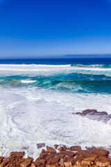 Powerful waves crash against rugged coastal rocks