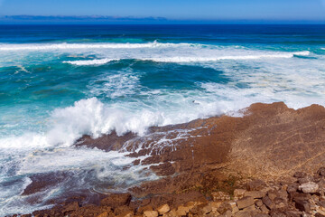 Powerful waves crash against rugged coastal rocks