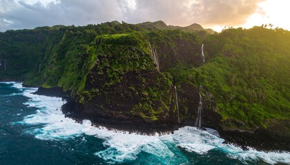 Aerial view of lush coastline with waterfalls at sunset