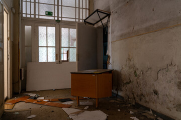 Abandoned attic interior with old wooden chairs and table under a damaged ceiling, sunlight...