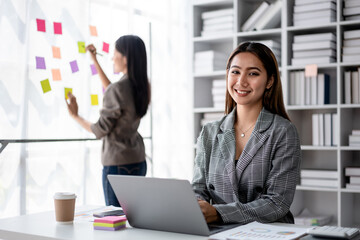 Asian Business Woman Working on Laptop in Modern Office Smiling Planning with Sticky Notes Brainstorming Strategy for Project Management Success