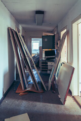 Abandoned attic interior with old wooden chairs and table under a damaged ceiling, sunlight...