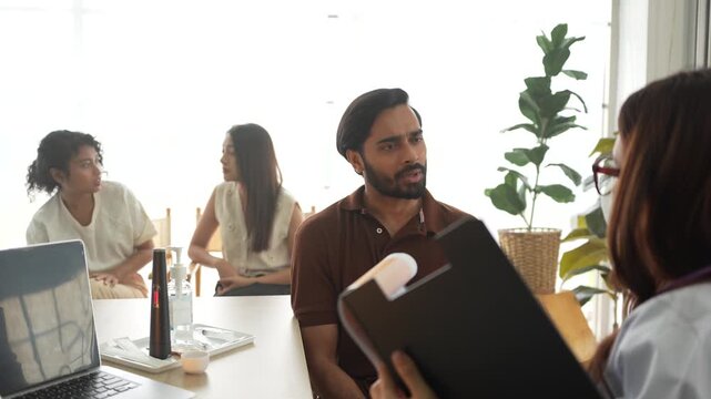A licensed therapist conducts a group psychotherapy session, addressing a patient's concerns. The session focuses on cognitive behavioral therapy (CBT) and peer support dynamics.