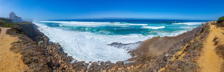 A panoramic coastal view showcases powerful waves
