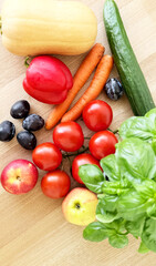 Farm-Fresh Vegetables and Fruit on Wooden Table — Top-View Vegetarian Flat Lay with Basil, Tomatoes on the Vine, Red Bell Pepper, Cucumber, Butternut Squash, Carrots, Lemon, Apples, Plums and Blueberr