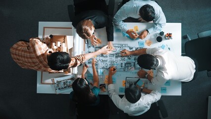 Top aerial view of project manager or civil engineer writing at blueprint and planning building...