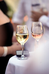 Glasses of white and rosé wine resting on table at social event