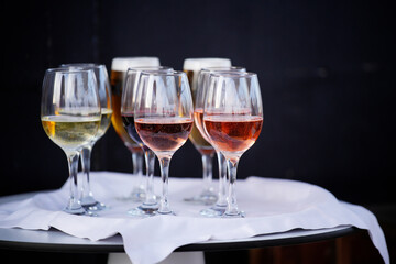 Wine glasses standing on table with white tablecloth displaying variety of wine types