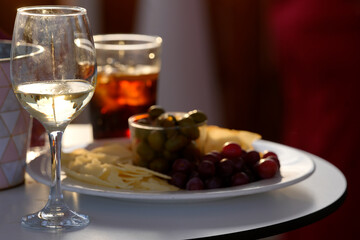 Wine, cheese, grapes, and olives creating an elegant appetizer platter