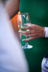 Woman holding glass of white wine at social event