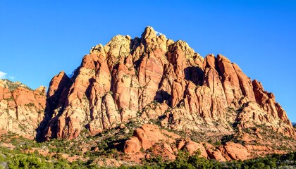 Fototapeta premium Red rock mountain peak against a clear sky