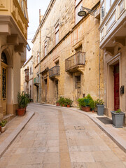 Obraz premium Narrow old stone street with balconies in Birgu, Malta.