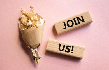 Join us symbol. Concept word Join us on wooden blocks. Beautiful pink background with bouquet of...