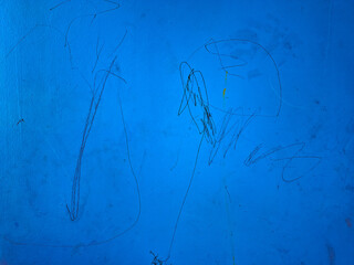 Vibrant Blue Painted Surface with Childlike Black Markings and Scratches