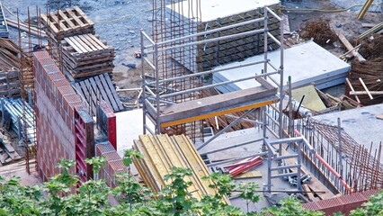 Fototapeta premium Messy Construction Site of Office and Residential Building with Rebar Reinforcement and Precast Concrete Slabs Corrugated Pipes and Wooden Formwork