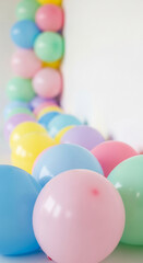Obraz premium Pastel-colored balloons arranged in a curved line against a white background, creating a festive and cheerful atmosphere, ideal for celebrations or party decorations