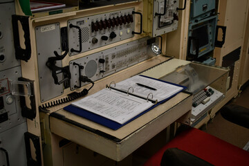 Nuclear ICBM control center. Procedure book open in front of missile launch station.