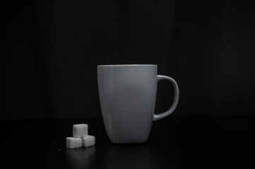 Centered mug with sugar cubes, dark gradient backdrop