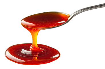 A spoon holding amber liquid, dripping onto a surface