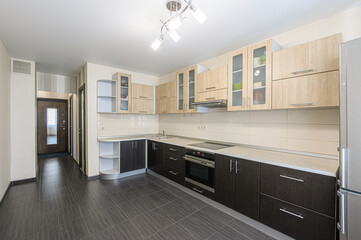 kitchen with light and dark wood cabinets, a white countertop, and gray tile flooring. A doorway is visible to the side