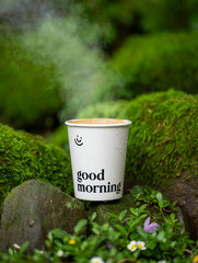 Steaming Coffee in a Mossy Forest Setting: Good Morning Message on Cup