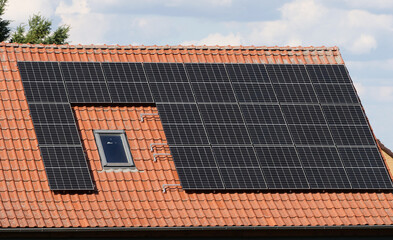 Photovoltaic system solar cells on a red roof for renewable energy generation, sustainable energy