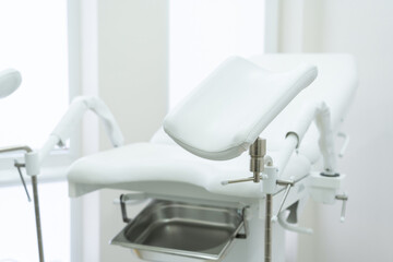 Empty white gynecological chair in modern medical center