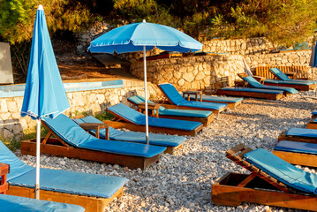 Equipped pebble beach Adriatic Sea, empty sunbeds at sunset, Utjeha, Montenegro