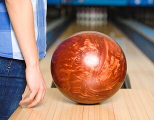 Woman holding bowling ball in alley