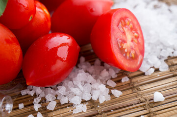 Fresh ripe cherry tomato, sea salt on wooden background	