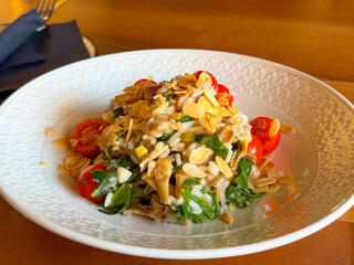 Rice with spinach, tomato and almond flakes served in plate. Healthy cuisine, nutrition, and vegetarian lifestyle highlighting wellness and culinary balance.