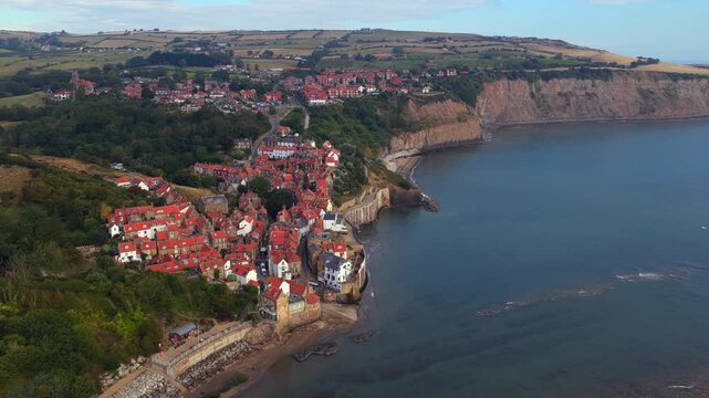 Established aerial video of Robin Hood&rsquo;s Bay, Yorkshire coast, highlighting its cluster of red rooftops, dramatic cliffs, and the surrounding countryside meeting the North Sea.