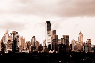A modern city with towering skyscrapers under a dramatic cloudy skyThe sepia tone effect creates an urban and artistic atmosphere perfect for business architecture and cityscape themes Here in Bangkok