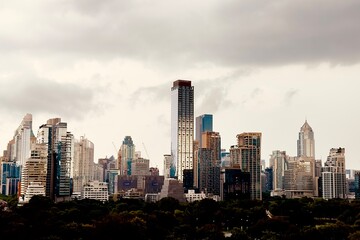 A modern city with towering skyscrapers under a dramatic cloudy skyThe sepia tone effect creates an urban and artistic atmosphere perfect for business architecture and cityscape themes Here in Bangkok
