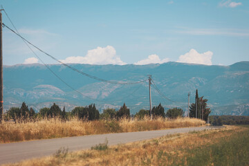 Serene rural landscape with rolling hills and scattered clouds on a peaceful sunny day