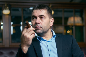 handsome man smoking cigar in a lounge bar