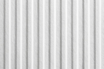 Close-up of a textured, white corrugated surface.  Vertical, parallel ridges create a subtle, repeating pattern