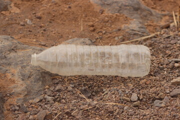A plastic bottle laying on the ground, Plastic pollution, Plastic environmental impact