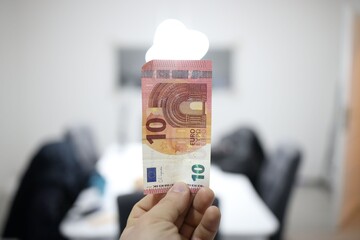 10 euro banknote held upright indoors. © Wirestock