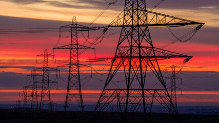 High Voltage Power Lines Against a Vibrant Sunrise Sky
