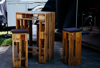 Rustic wooden outdoor table and stool set on sunlit patio