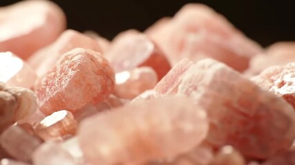 Hero macro shot of pink Himalayan salt crystals sparkling in soft spotlight - Powered by Adobe
