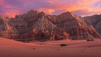 Fototapeta premium Dramatic Sunset Over Layered Rock Formations in a Desert Landscape
