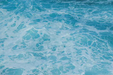 Obraz premium Sea surface aerial view. Background shot of clear sea water surface. Blue sea water in calm. Sea texture. Background blue waves of the ocean 