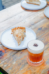 Delicious cake slice and iced coffee with star anise on a wooden table inviting enjoyment