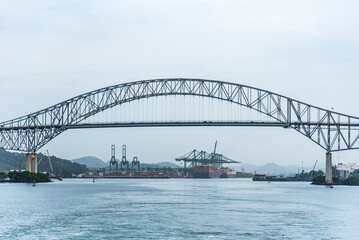 Bridge of Americas in Panama spans over a waterway, viewed from a transiting cargo ship. 