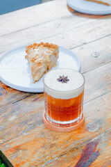 Refreshing cocktail and delicious dessert slice on a rustic wooden table for cafe menus