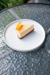 Delightful slice of creamy cheesecake with lemon garnish on a white plate for a refreshing treat